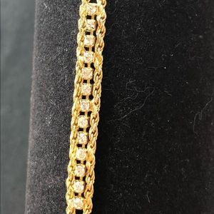 Gold tone tennis style bracelet with CZ stones.